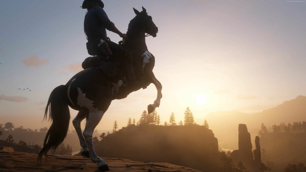 Arthur Morgan on horseback silhouetted against a golden sunset in Red Dead Redemption 2